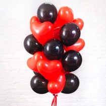 Облако из 21 латексного шара: 9 круглых черных шаров и 12 красных шаров в форме сердец, наполненных гелием.